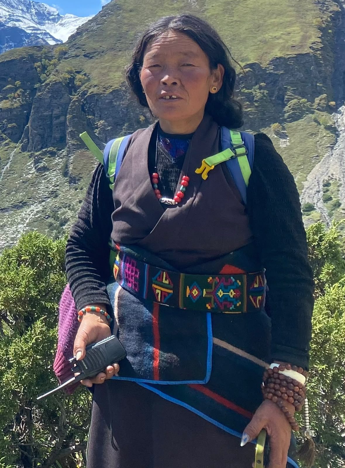 Sonam's mother in traditional dress, mountains behind her